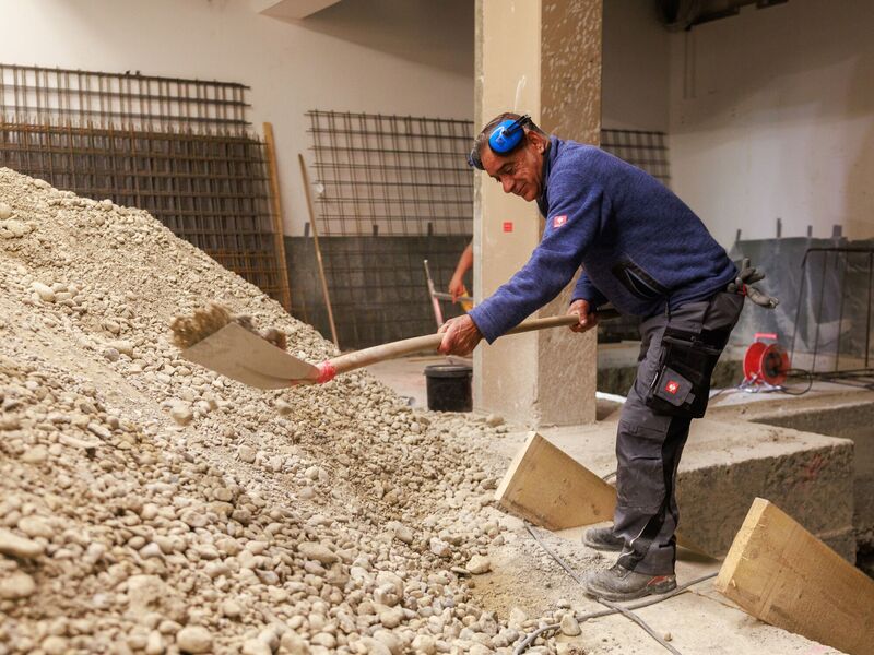 Zwei Bauarbeiter auf Baustelle mit Bauplan
